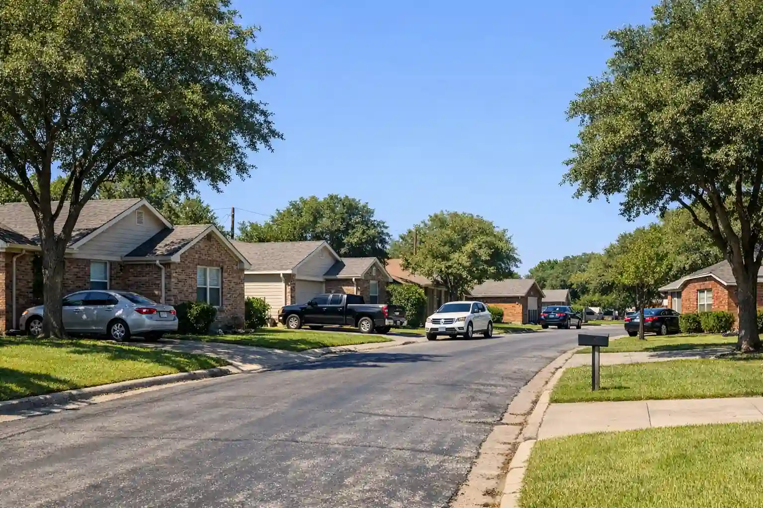 Typical residential homes in a Dallas County neighborhood with green lawns under a blue-sky background representing property tax subjects.